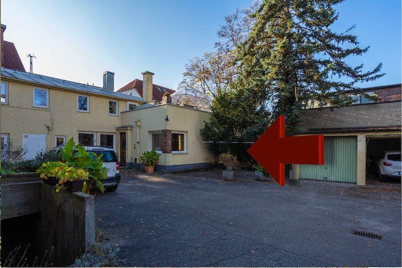 Ein Pfeil, der im Innenhof auf die Osteopathiepraxis von Christian Kästle zeigt
