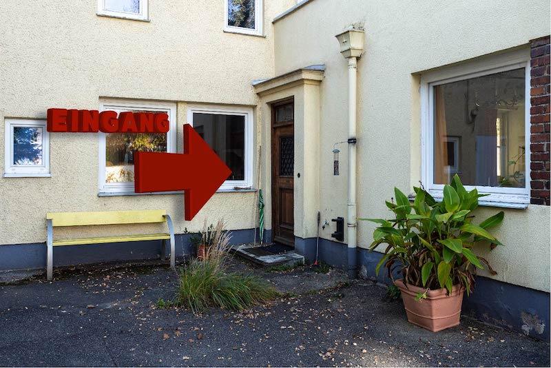Ein Pfeil, der auf die Eingangstüre der Osteopathiepraxis von Christian Kästle zeigt